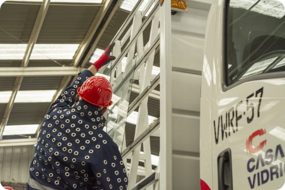 Operario de Casa Vidrios trasladando un rack de planchas de vidrio en la bodega