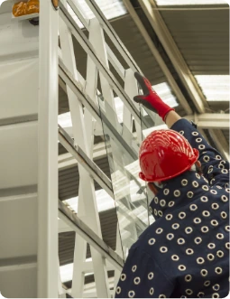 Operario de Casa Vidrios seleccionando planchas de vidrio en el rack de la bodega