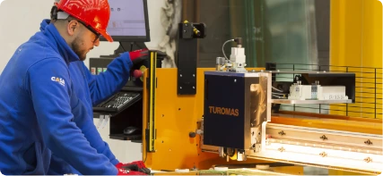 Trabajador de Casa Vidrios operando la máquina de corte de vidrio